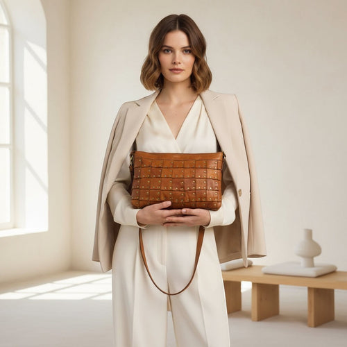 Modella indossa borsa a tracolla Pito’s|Bag in pelle marrone con borchie quadrate in stile rock-chic