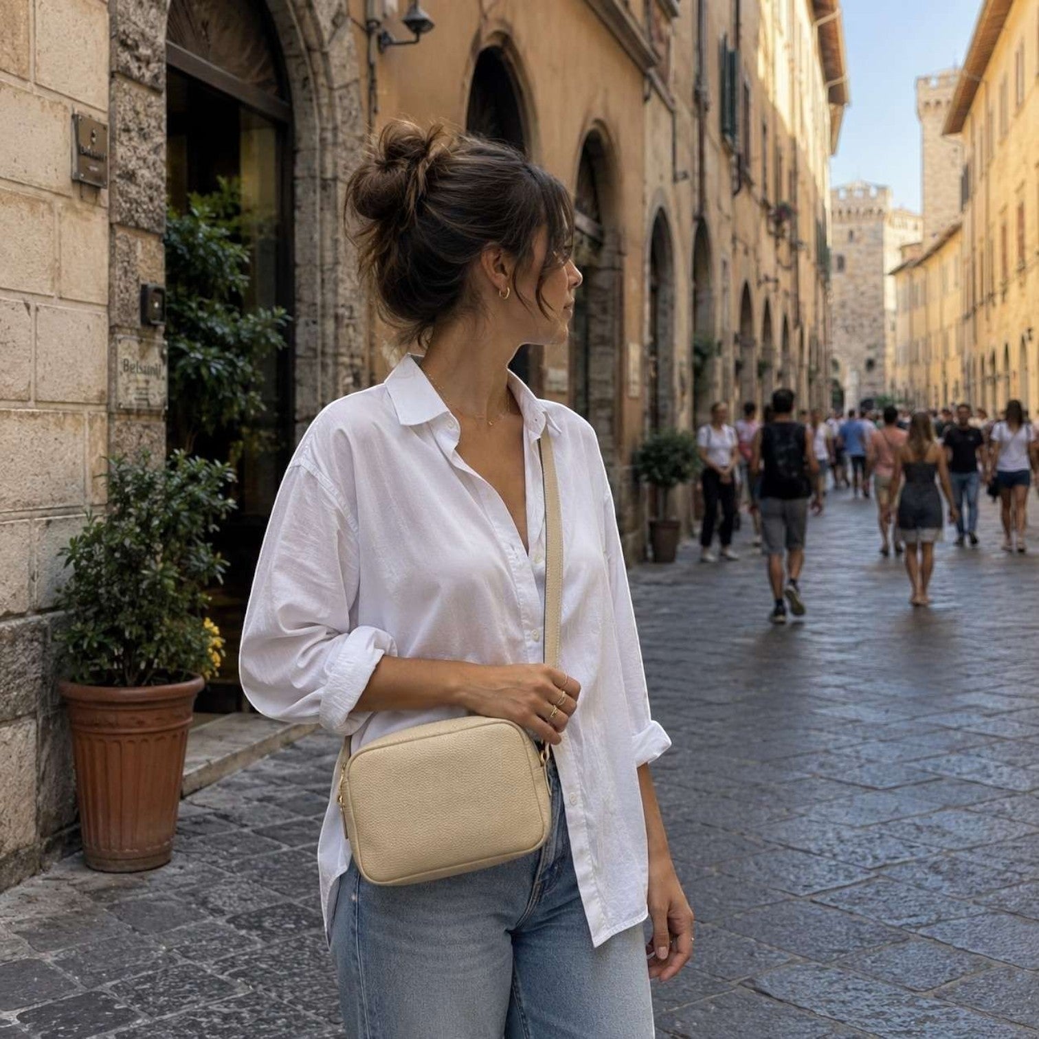 Donna che indossa la borsa a tracolla Miriam di Pito’s|Bag in vera pelle martellata color crema in una via storica