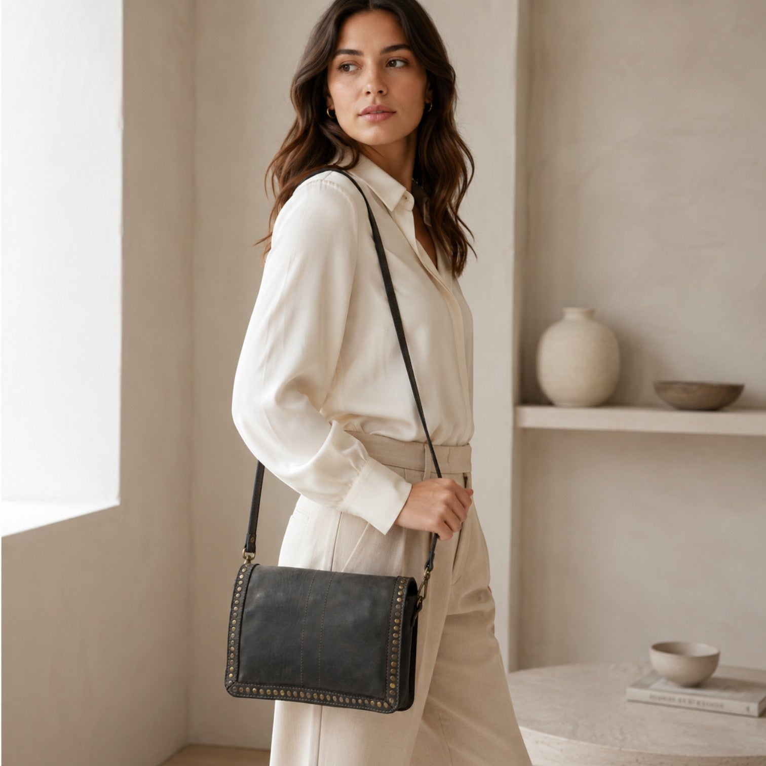 Modella indossa borsa a tracolla Pito’s|Bag in vera pelle nera tinta in capo con dettagli in ottone e tracolla sottile