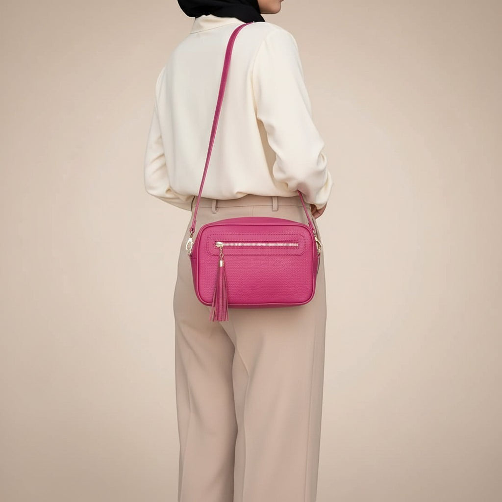 Tracollina Pito’s|Bag in vera pelle fucsia con zip, nappina decorativa e tracolla regolabile indossata da una modella